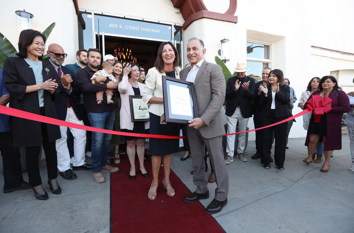 Mo Honarkar receiving a framed civic recognition outside Hotel Laguna as guests applaud.